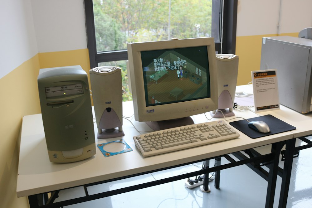 A mid-2000s desktop computer: beige tower, CRT monitor, keyboard, mouse and desktop speakers. Photo by P. L. on Unsplash.